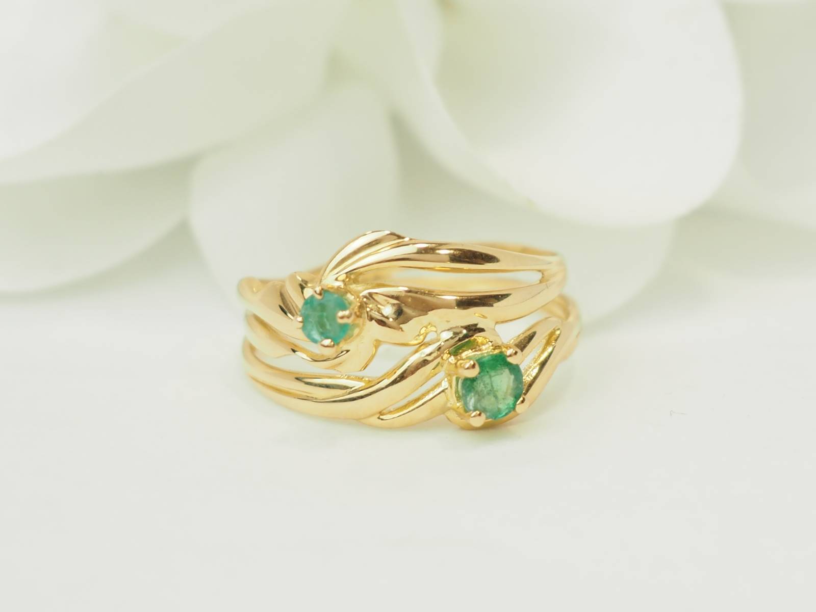 Bague vintage en or jaune 18 carats sertie de deux émeraudes naturelles.